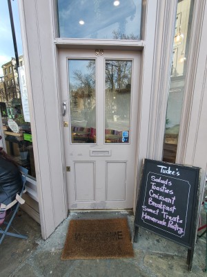 Pink framed glass door. Push silver handle on left to open.