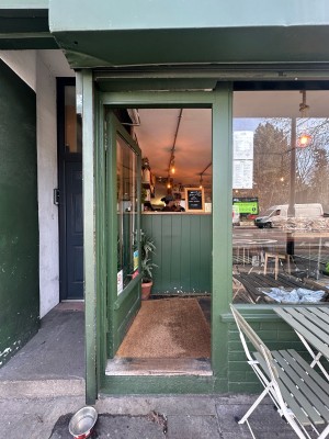 Glass door with green frame. Push silver handle from right to open.