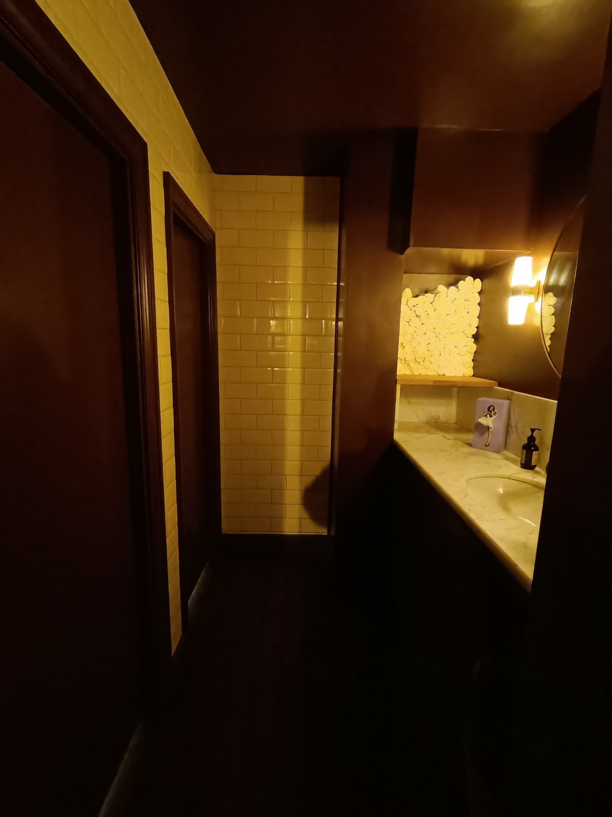 From doorway, looking straight. Sink on right. Cubicles on left.