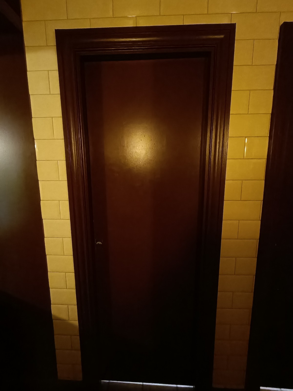 From sink, looking left. Brown wooden door ahead. Push from left to open.