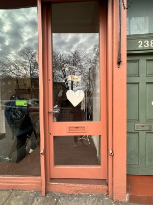 Glass door with pink frame. Push silver handle from left to open.
