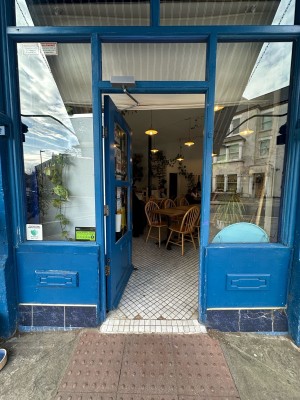 Blue and glass panelled door. Push silver handle from right to open.