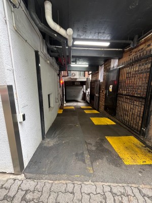 Path to entrance from street. Door on left wall ahead.