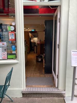 Glass door with white frame ahead. Push to open from left.