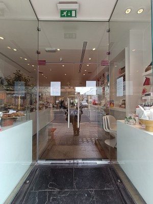 Glass doors with silver metal handle in middle. Push from middle to open.