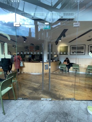 Glass doors ahead. Push sliver handles in center to open.