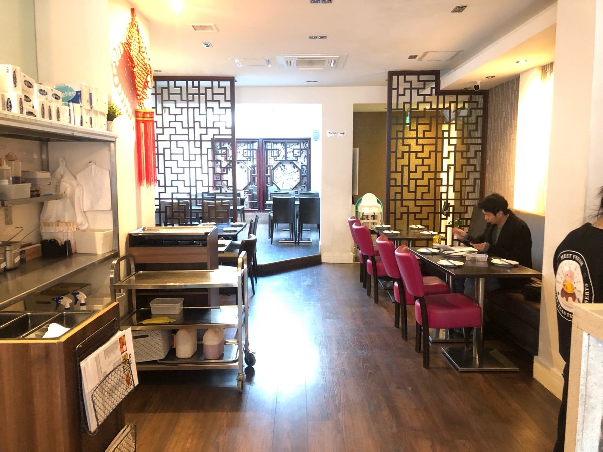 From end of counter facing left. Condiment station on left, half booth behind and along right wall. Step to back area at back.