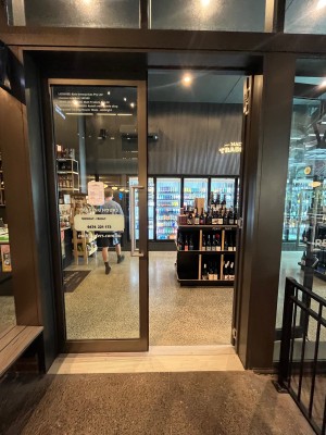 Glass doors with grey metal frame and silver handles in middle. Push to open.