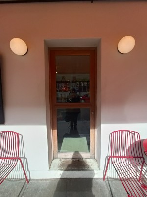 Glass door with brown wooden frame. Push from right to open.