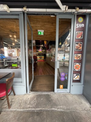 Glass doors with metal frame. Push sliver handle on right to open.