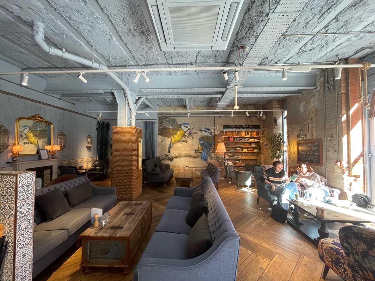From after bar facing straight. Low table and couches on left and at back. Pillar at back left.Armchairs and low tables on right.