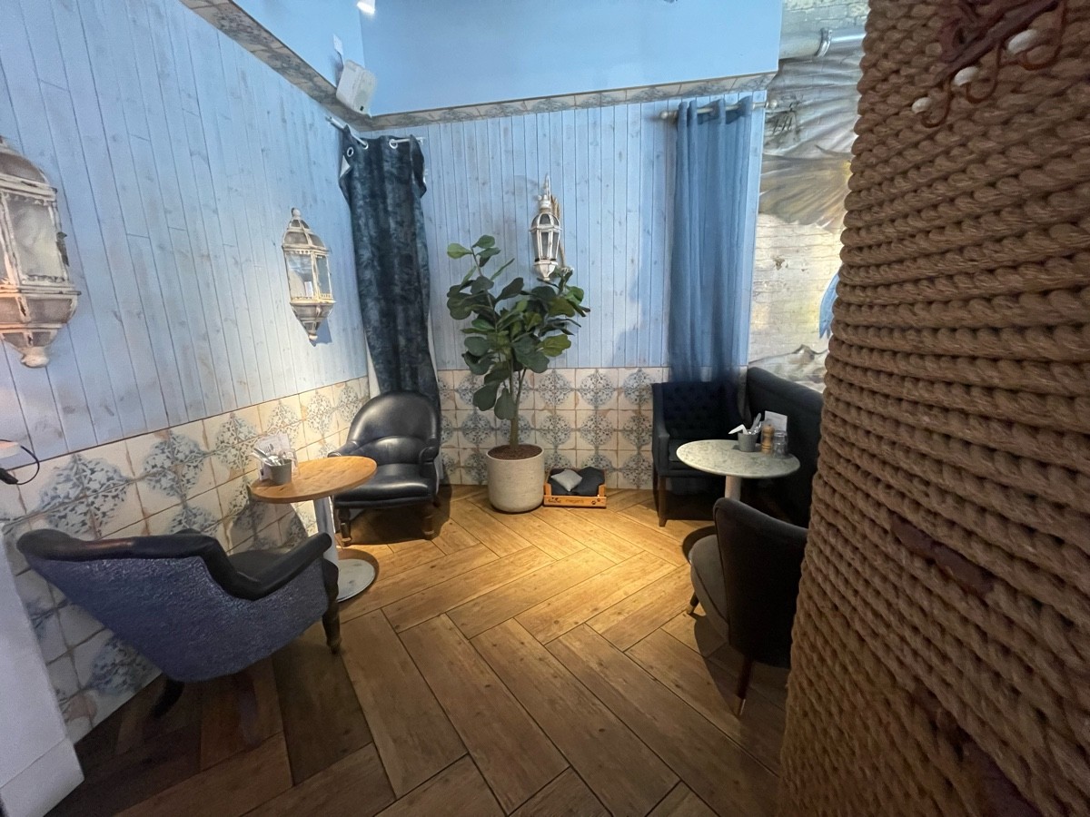 From pillar facing right. Armchairs and tables on left right.