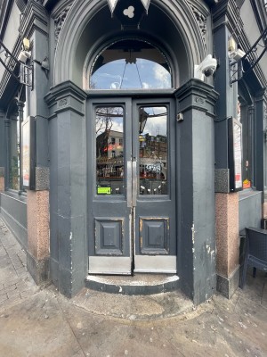 Glass paneled doors with dark wooden frame ahead. Push in center to open.