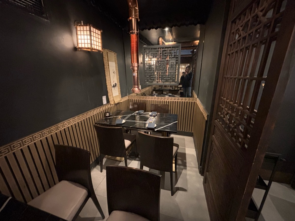 From doors facing right. Tables and chairs along left.