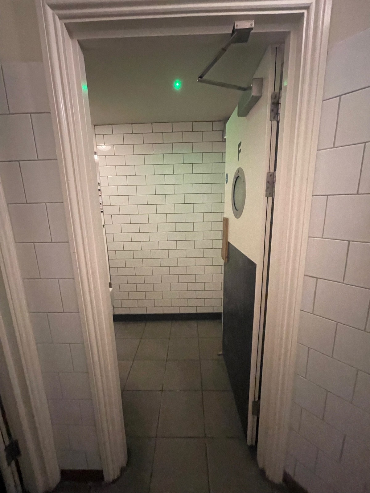 From path facing straight. Preceding white bathroom door. Push on left to open.