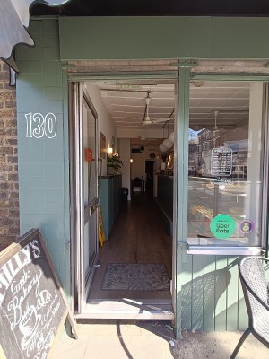 Glass door with silver metal frame. Push silver handle on right to open.