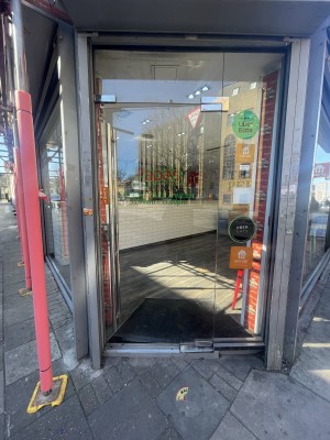 Glass door ahead. Push silver metal handle on left to open.