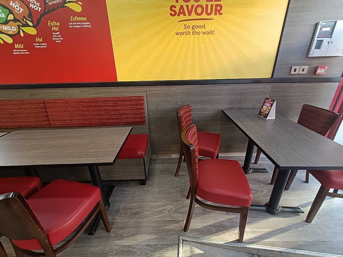 From entrance, looking right. Half-booth along back left. Tables and chairs ahead on right.