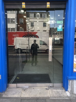 Glass door, push from right. Built-in ramp ahead of entrance.