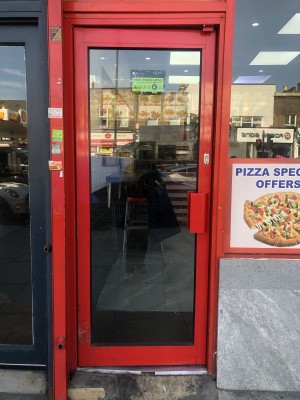 Glass door with red frame. Push handle on right to open.