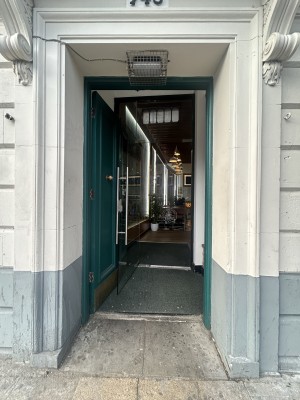 Green wooden preceding door ahead. Push gold handle in centre and from right to open.