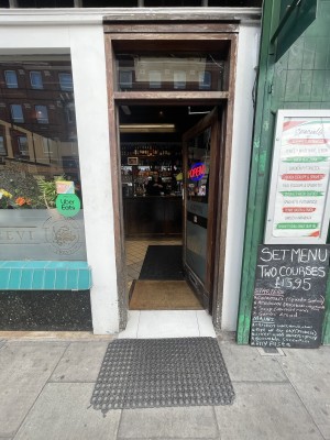 Glass door with brown wooden frame ahead. Push from left to open.