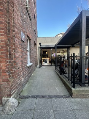 From street facing venue. Opening ahead with built in ramp up to entrance at back. Opening to outdoor seating on back right.