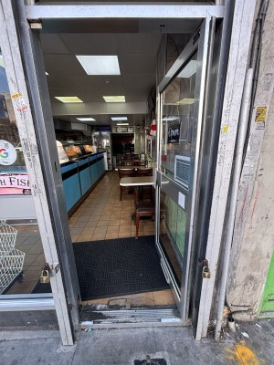 Glass door with silver frames. Push on left to open.