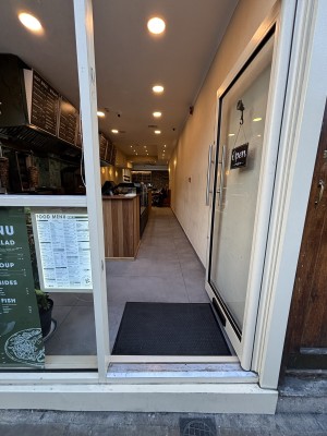 Glass door with white frames. Push on left to open.