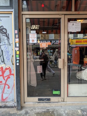 Glass door with metal frame and metal handle on right. Push to open.