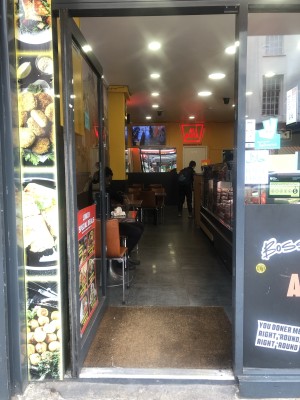 Glass door with black frame. Push handle on right to open.