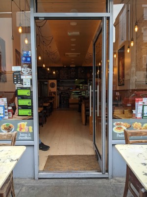 Glass door with silver metal handle on left. Push to open.