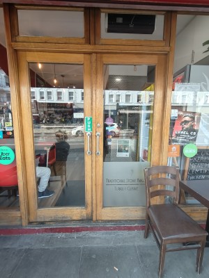 Wooden framed glass doors. Push silver handles in centre to open. Chair on right.