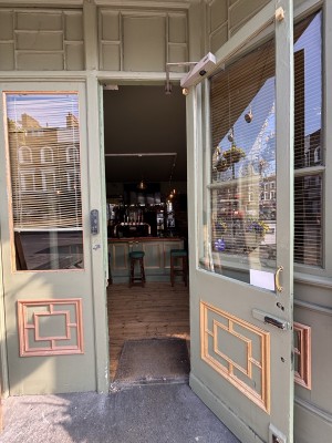 Glass door with green frames. Pull from left to open.