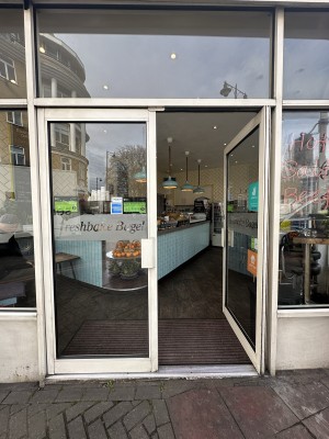 Glass doors with white frame ahead. Push white handles in centre to open.