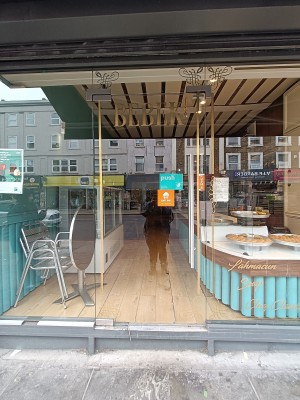 Glass door with silver handle on right. Push to open.