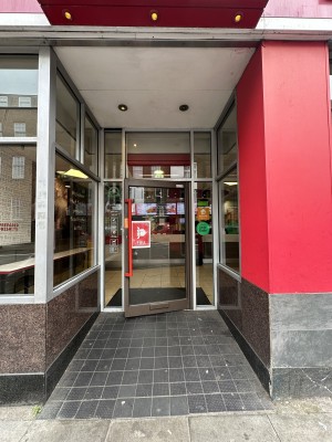 From Street facing venue. Opening ahead. Ramp up from foot of opening leading to door at back.