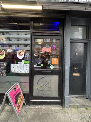 Glass door with black frames. Push on left to open.