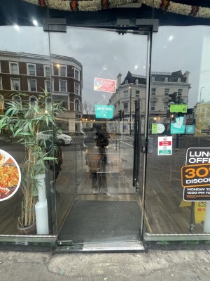 Glass door ahead. Push black metal handle on right to open.