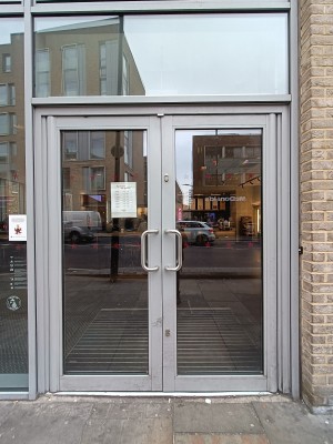 Glass doors with silver metal frame. Push silver handles in middle to middle.