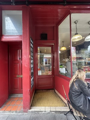 Red and glass panelled door. Push from right to open.