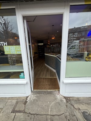 Glass door with white frame ahead. Push from right to open.