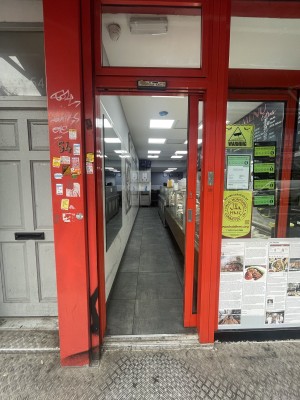 Glass door with red frame ahead. Door slides from left to right upon entrance.