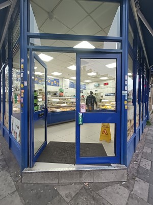 Glass door with blue frame. Push from middle to open.