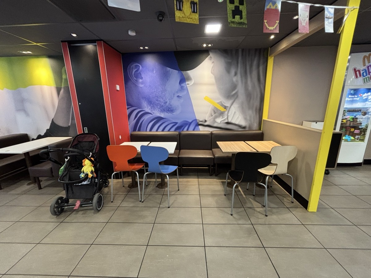 From after self ordering screen facing left. Half booths at the back wall.