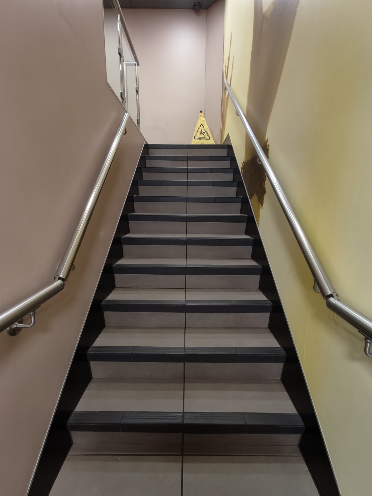 From landing facing straight. Stairs continue up. Handrails on both sides.