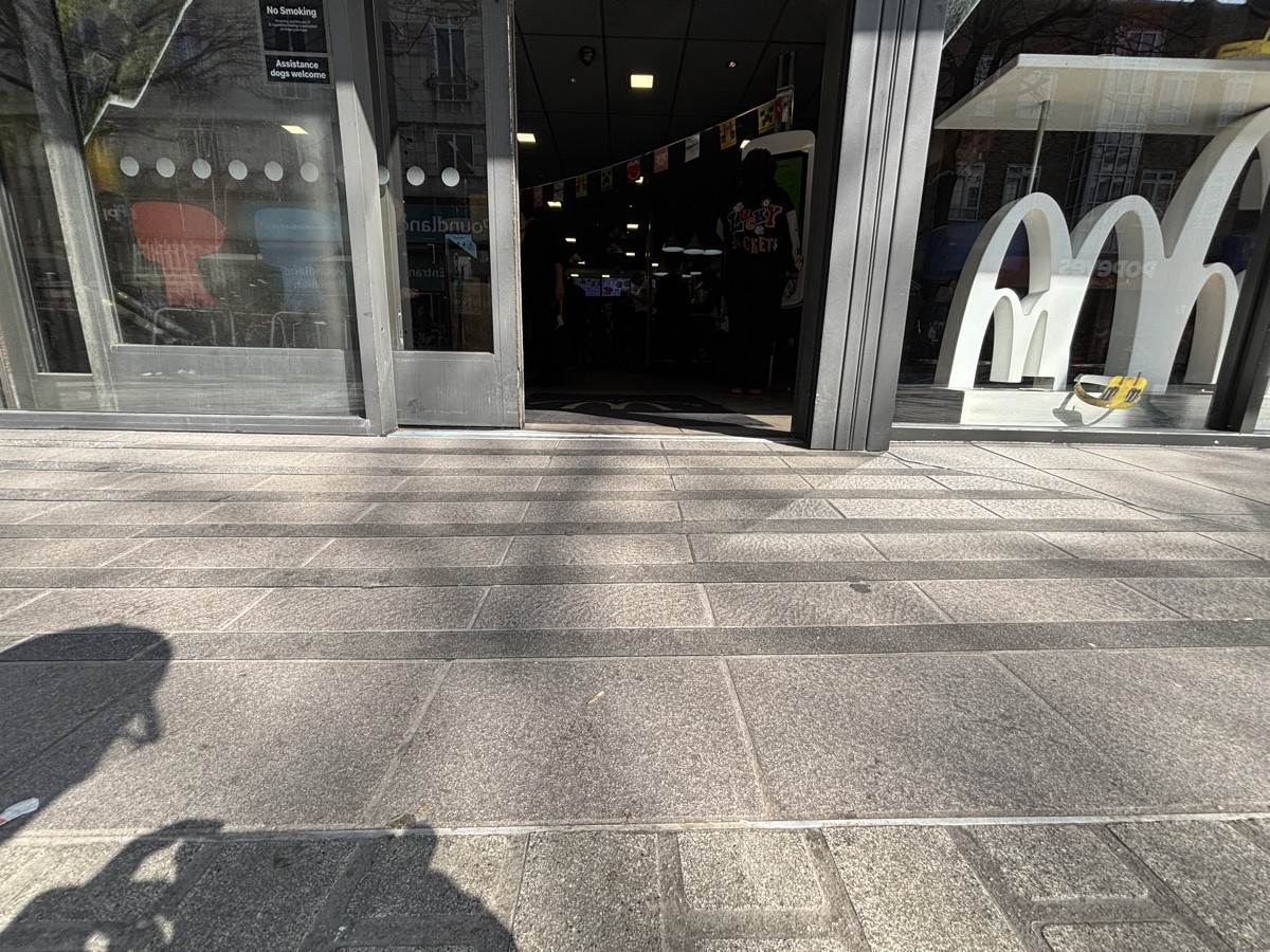 A slope up before entrance. Bump at foot of door. Doormat after.