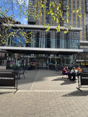 Opening ahead between restaurant barriers. Path behind to entrance on back with outdoors seating along both sides.
