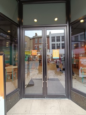 Glass doors with black frame. Pull silver handles from middle to open.