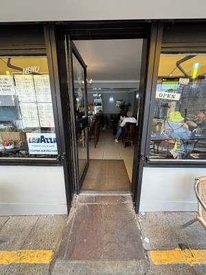 Glass store with black frames. Push on right to open.